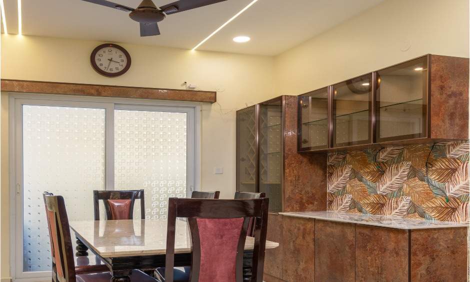 Dining interior in Nizampet, Hyderabad with wood-finish crockery unit and glass doors