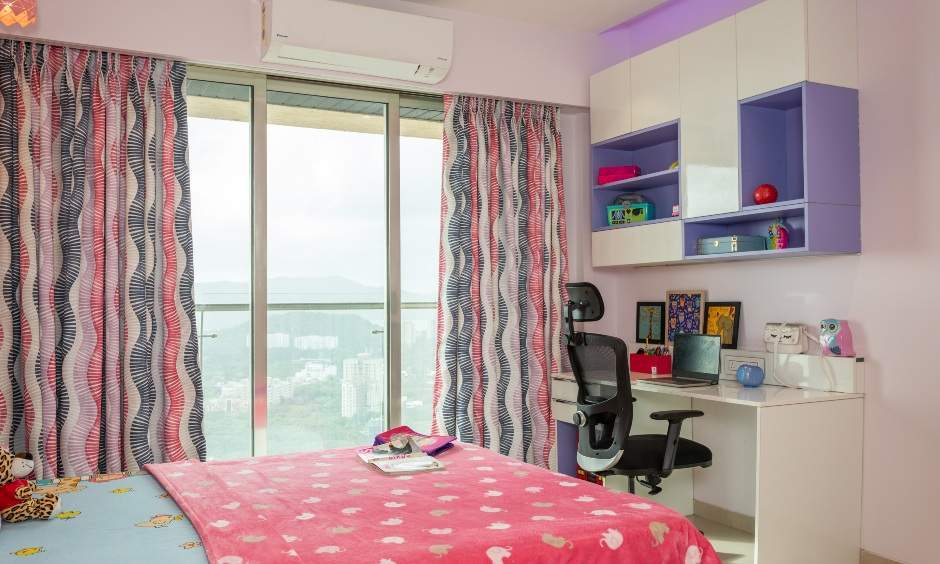 Vibrant kids' bedroom in Powai Mumbai with a study unit, wall shelves, spacious desk, and hidden storage.