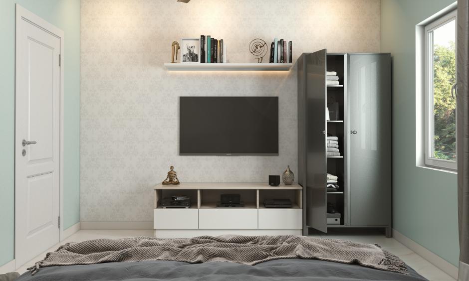 Stainless steel wardrobe with open shelves placed beside a TV unit in a compact bedroom