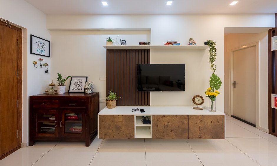 TV unit with dual-finish against wooden panel in 2bhk interior design house