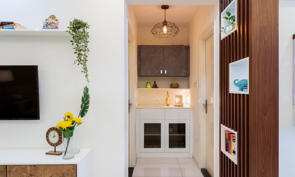 Foyer area features a white storage unit with glass shutters and a brown overhead cabinet