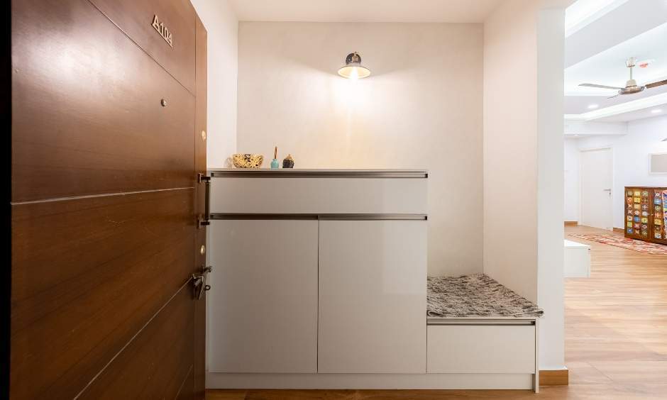 Minimalist foyer in Sattva Greenage 3BHK flat: White storage unit with seating area.