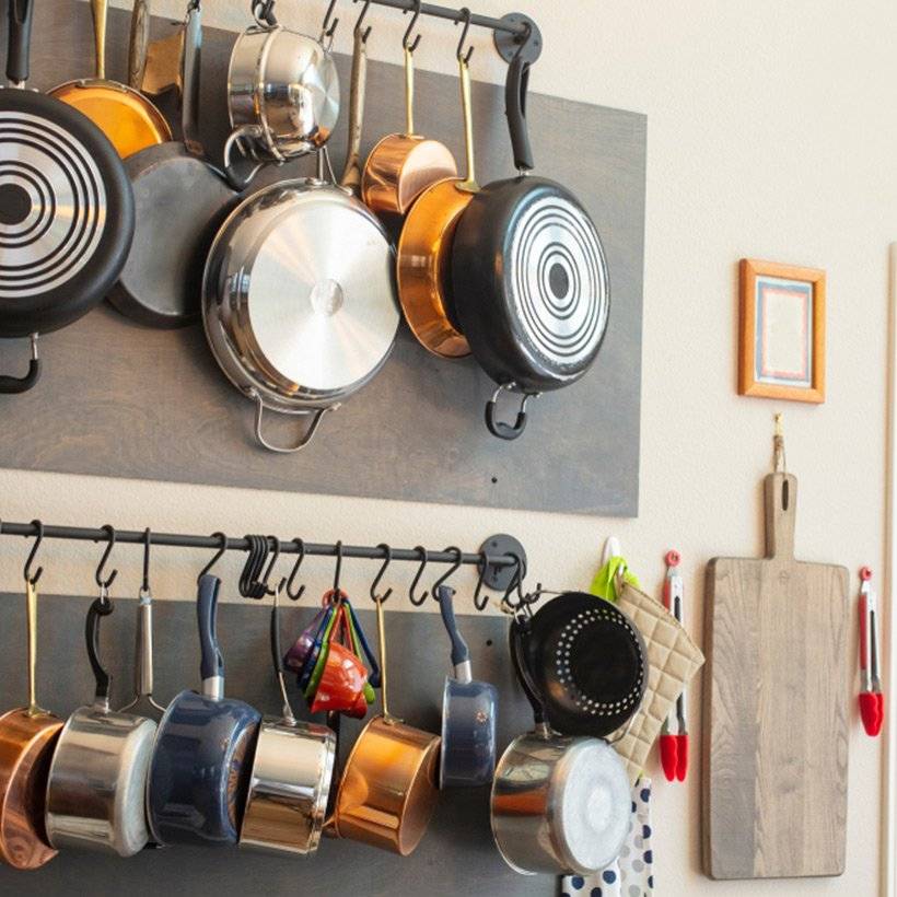 Kitchen organisation tips to store all the pans at one place by hanging them on the wall on a horizontal rod for kitchen organization
