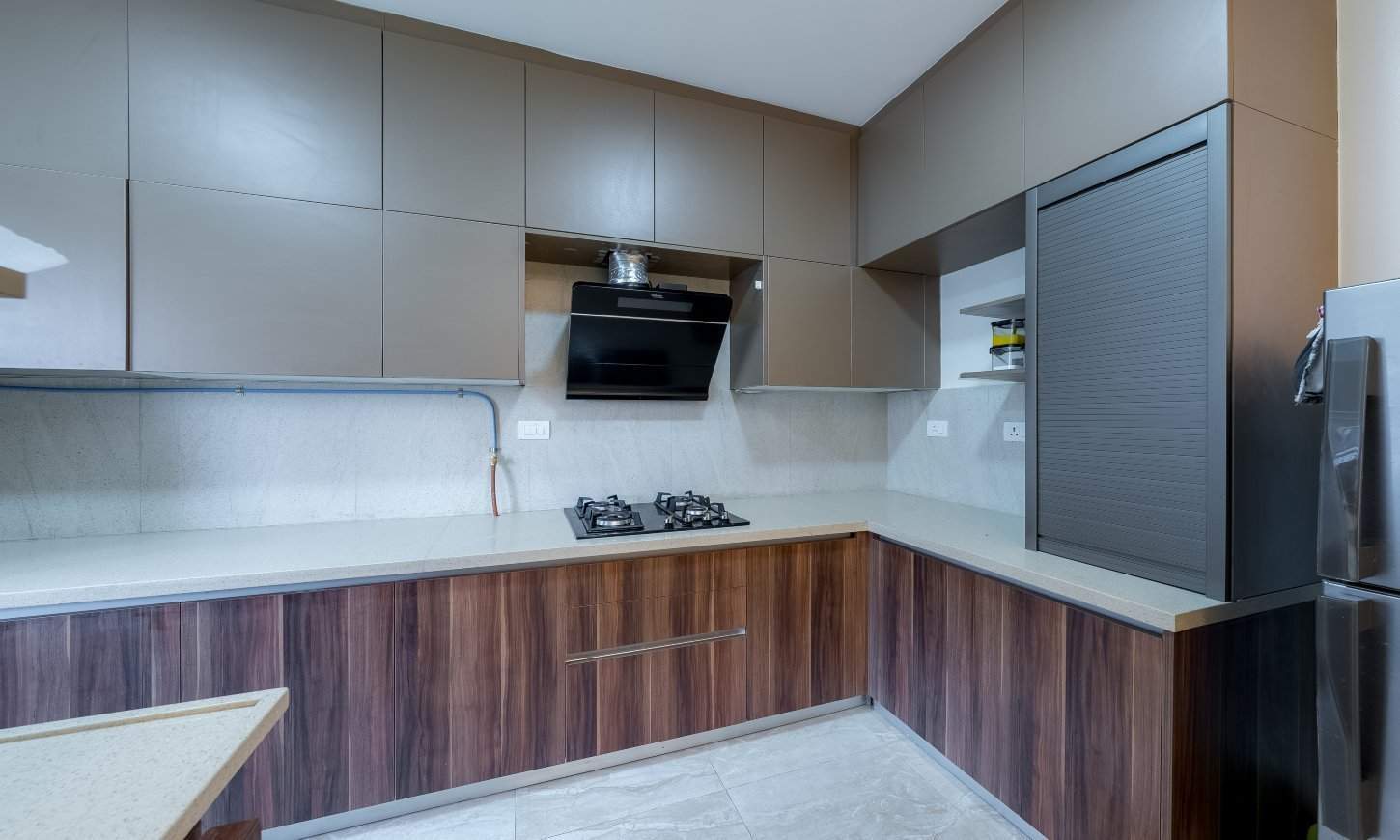 Designcafe designed an l-shaped modular kitchen in Sarjapur Road with push-to-open overhead cabinets