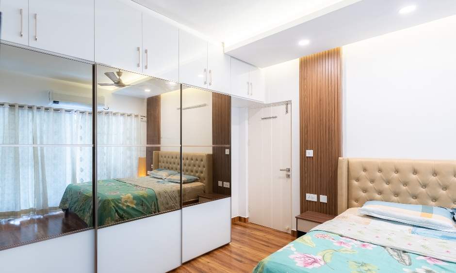Master bedroom with floor-to-ceiling wardrobe and full-size mirror, designed in Bommanahalli by DesignCafe
