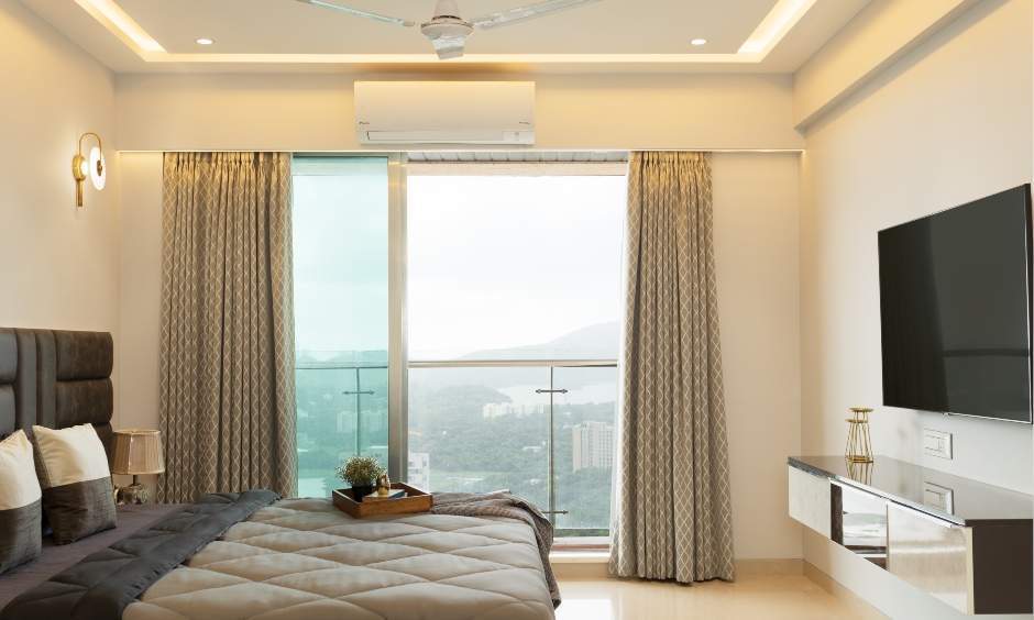 Minimalist master bedroom with a wall-mounted TV unit in a 3BHK Powai residence.