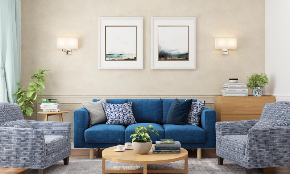 Living room with half-wall painted MDF panelling behind blue sofa and framed wall art