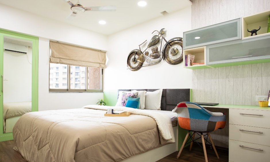 Metal bullet wall decor in the kid's room with a cosy study kook with a study desk and storage option designed by best interiors in mumbai