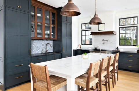 L‑shaped kitchen with shaker cabinets, copper handles and white splashback