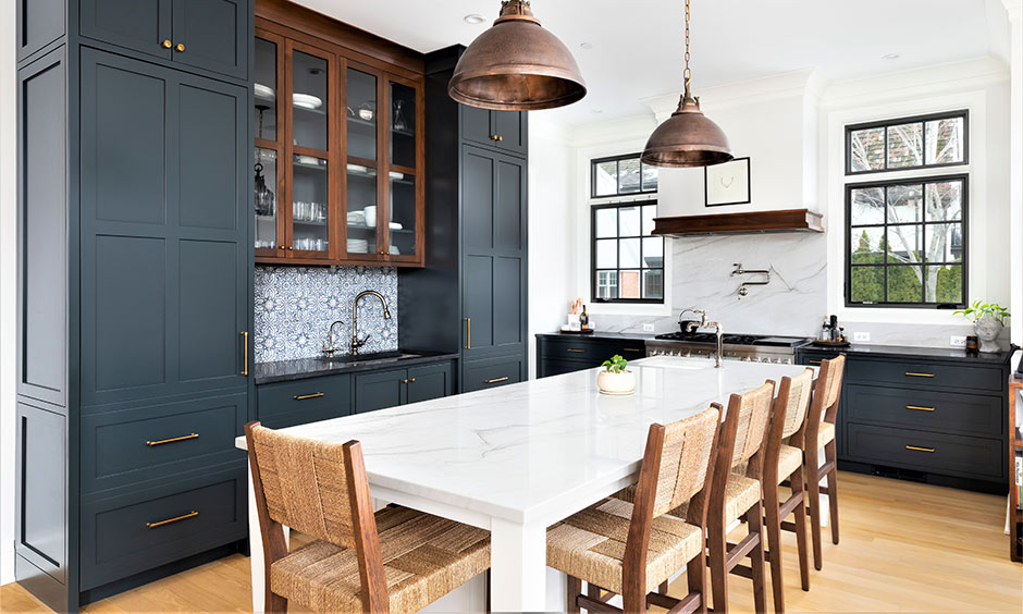 L‑shaped kitchen with shaker cabinets, copper handles and white splashback