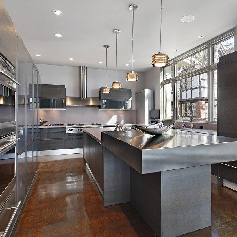 Stainless steel cabinets with hanging lamps made up of steel and countertop also made up of steel