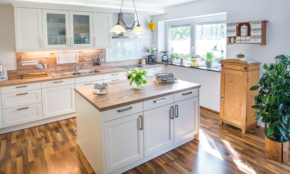Rustic biophilic kitchen with wood flooring, cream cabinetry, and potted plants